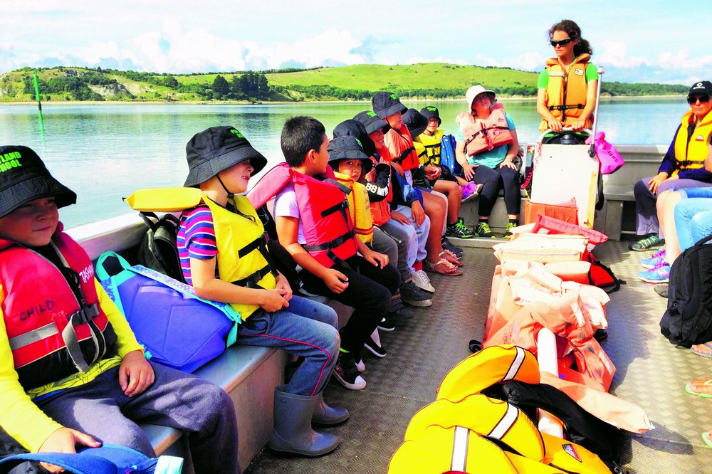 Children wearing lifejackets on a boat.