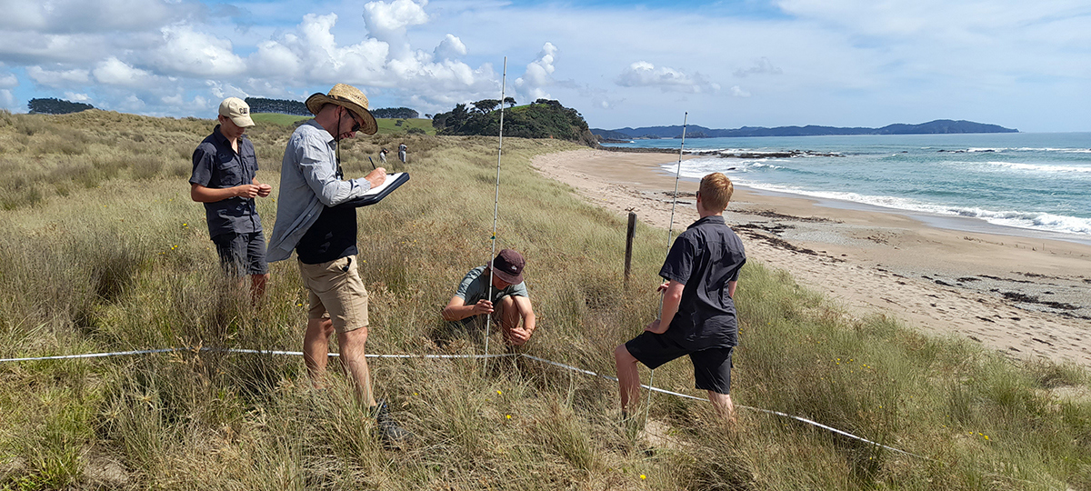 People on sand dunes recording monitoring information