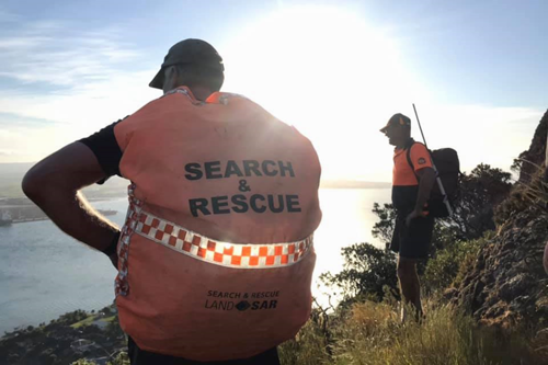 Search and rescue people looking at coast.